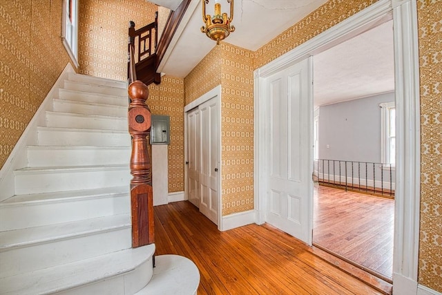 stairs featuring baseboards, hardwood / wood-style flooring, and wallpapered walls