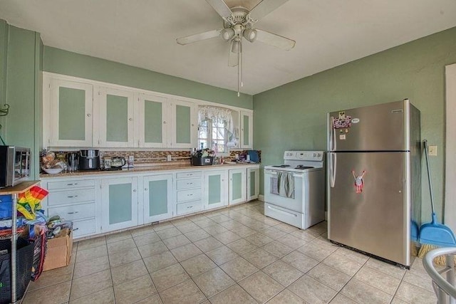 kitchen featuring appliances with stainless steel finishes, white cabinets, glass insert cabinets, and light tile patterned floors