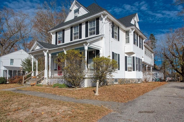 view of home's exterior featuring a shingled roof and a porch