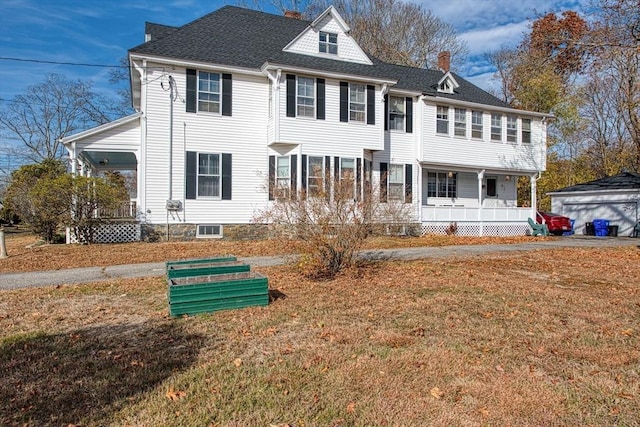 view of front of property featuring roof with shingles, a front lawn, a chimney, and a porch