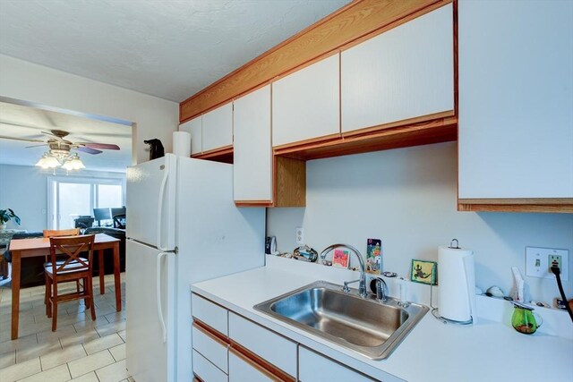 112 Olde Colonial Dr Unit 3, Gardner, MA 01440 - kitchen featuring a sink, light countertops, ceiling fan, white cabinetry, and freestanding refrigerator