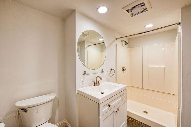 bathroom with vanity, toilet, and a shower