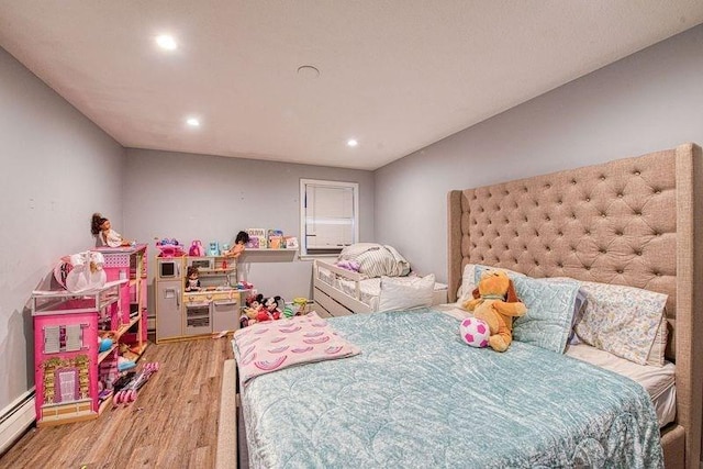 bedroom featuring hardwood / wood-style flooring and a baseboard radiator