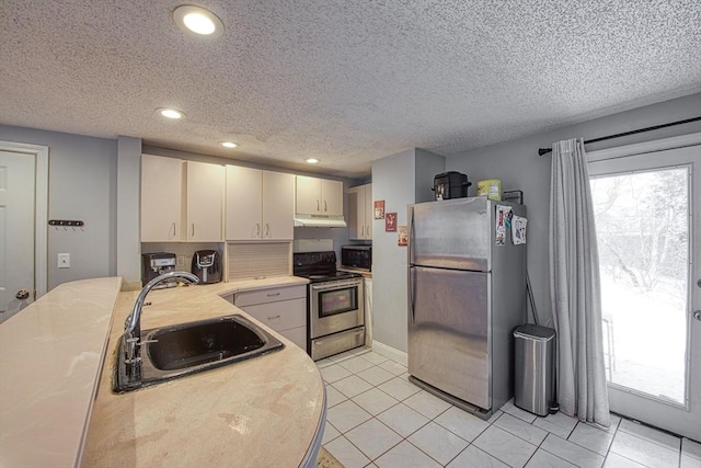 kitchen featuring plenty of natural light, stainless steel appliances, sink, and light tile patterned floors