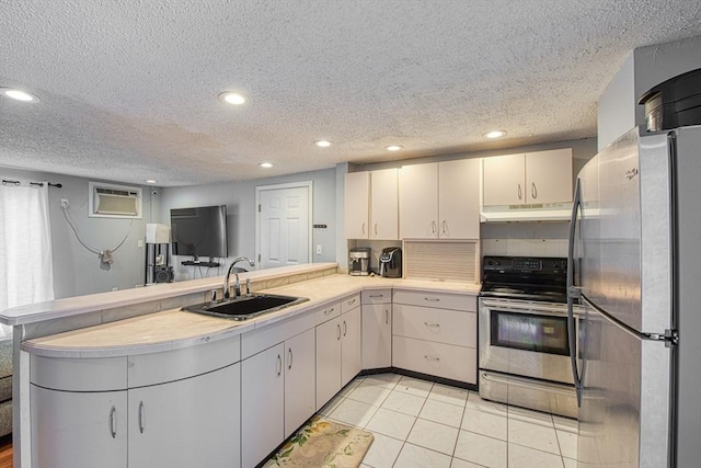 kitchen featuring sink, appliances with stainless steel finishes, a wall mounted AC, tasteful backsplash, and kitchen peninsula