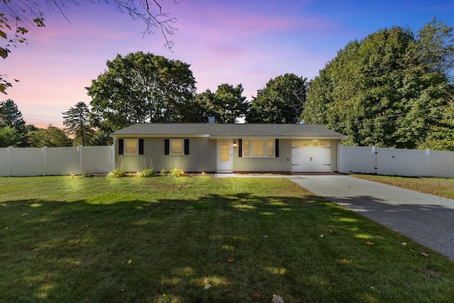 single story home with a garage and a yard