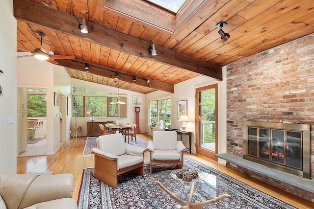 77 Temple Rd, Concord, MA 01742 - living room featuring wood finished floors, wooden ceiling, a skylight, rail lighting, and a brick fireplace