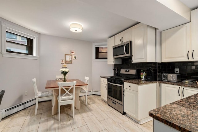 kitchen with stainless steel appliances, dark stone counters, decorative backsplash, and white cabinets