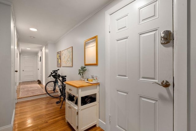 corridor featuring crown molding and light hardwood / wood-style flooring