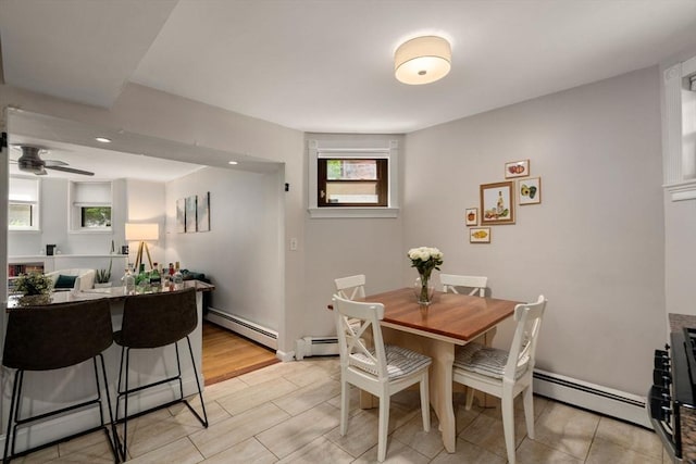 dining space featuring light hardwood / wood-style flooring, a baseboard radiator, and ceiling fan