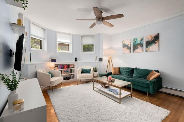 living room featuring wood-type flooring, ceiling fan, and a baseboard radiator