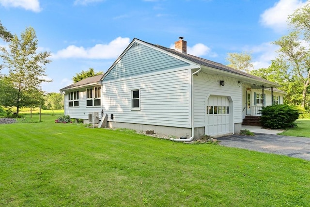 19 Shaker Ln, Littleton, MA 01460 - view of side of property featuring a chimney, an attached garage, driveway, and a lawn
