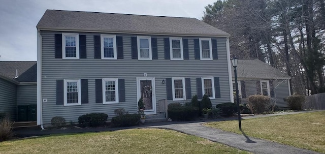 colonial house with entry steps and a front yard
