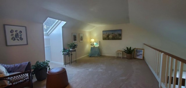sitting room featuring a skylight, lofted ceiling, carpet flooring, and baseboards