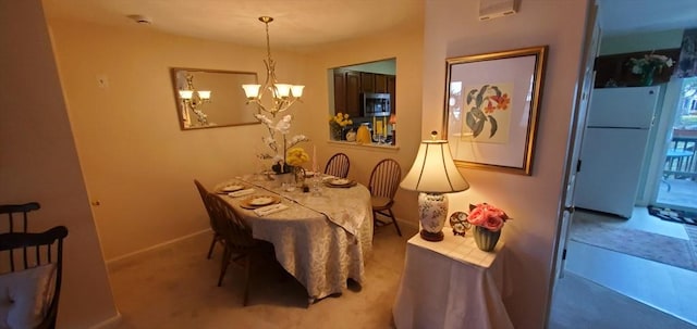 dining room featuring a chandelier, baseboards, and carpet flooring