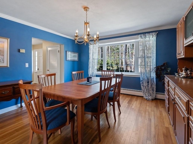dining space with crown molding, baseboards, light wood-style flooring, and a chandelier