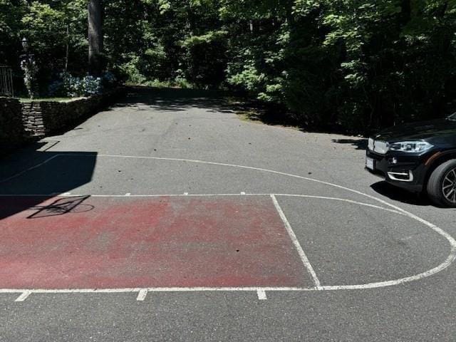 view of sport court with a wooded view