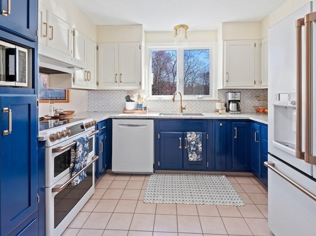 kitchen with a sink, backsplash, blue cabinets, and white appliances