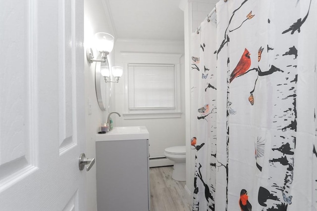 bathroom featuring hardwood / wood-style floors, vanity, toilet, ornamental molding, and a baseboard radiator