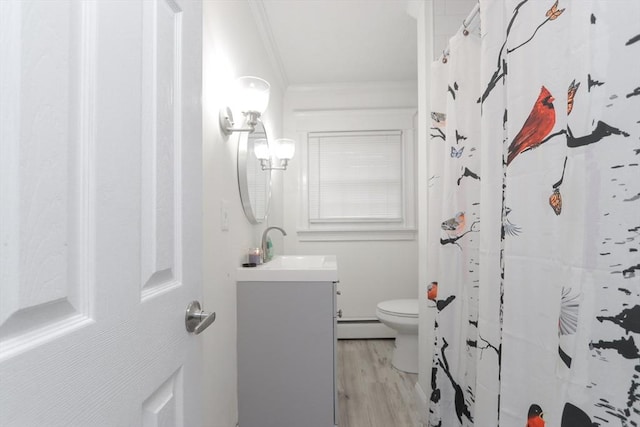 bathroom featuring ornamental molding, vanity, a baseboard heating unit, wood-type flooring, and toilet