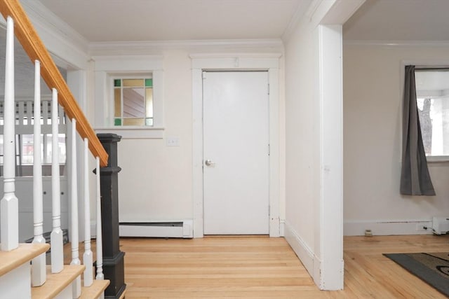 foyer featuring ornamental molding, light wood-type flooring, and a baseboard heating unit