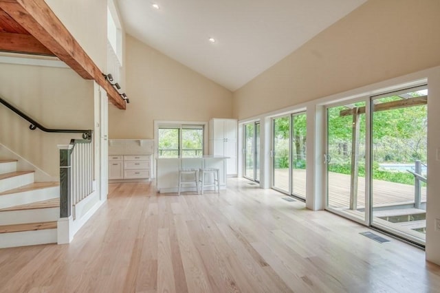 212 Charles Neck Way, West Tisbury, MA 02575 - unfurnished living room featuring high vaulted ceiling, light wood-style floors, stairway, and recessed lighting