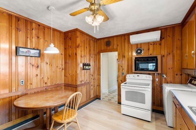 kitchen with white electric range oven, washer / clothes dryer, a wall mounted AC, wood walls, and brown cabinets