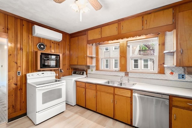 kitchen with dishwasher, washer / dryer, white electric range oven, an AC wall unit, and a sink