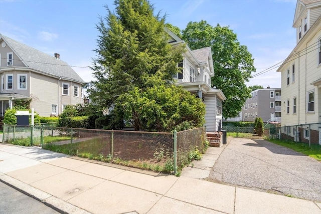 view of front of property with a fenced front yard, a residential view, and driveway