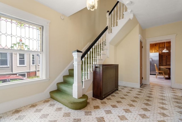 staircase with baseboards and tile patterned flooring