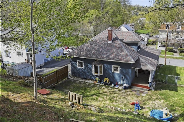 28 Upton St, Adams, MA 01220 - rear view of property featuring a storage shed, a chimney, fence, a shingled roof, and an outdoor structure