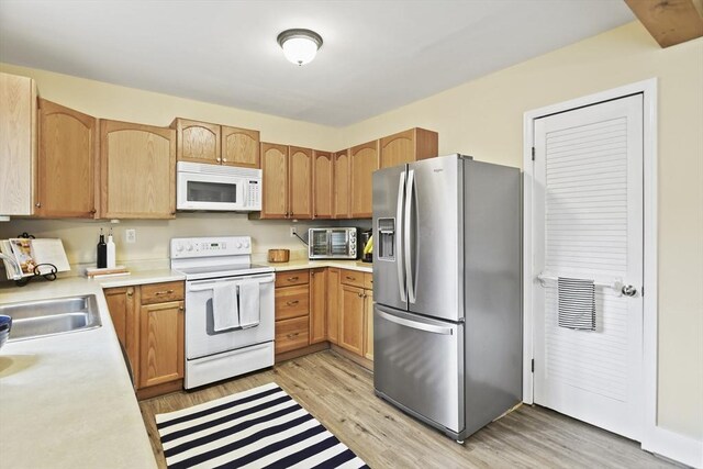 28 Upton St, Adams, MA 01220 - kitchen with a sink, white appliances, a toaster, light countertops, and light wood-style floors