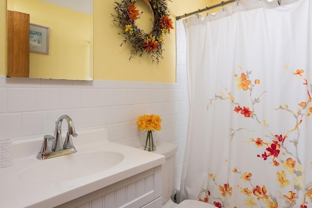 full bathroom featuring a shower with shower curtain, vanity, toilet, and tile walls