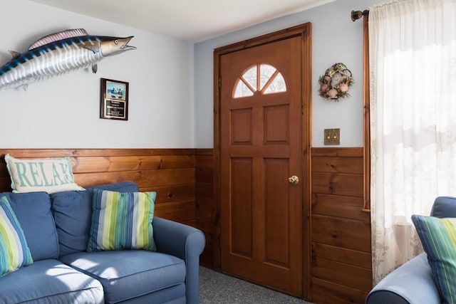 living area featuring a wainscoted wall, wood walls, and carpet flooring