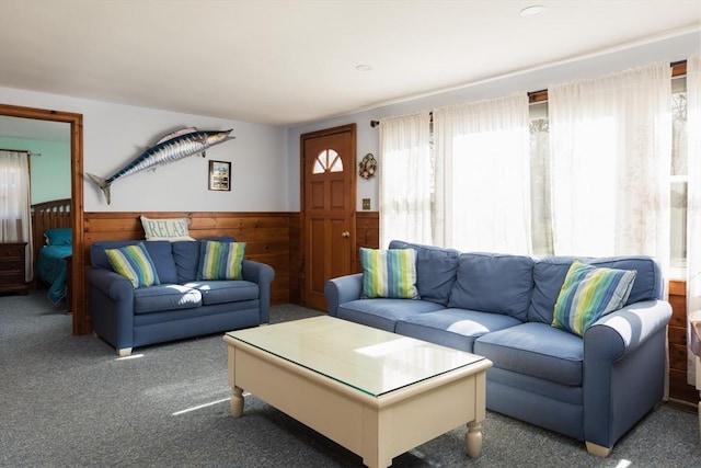 carpeted living room with wainscoting and wooden walls