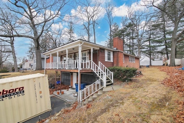 rear view of house with a porch and a garage