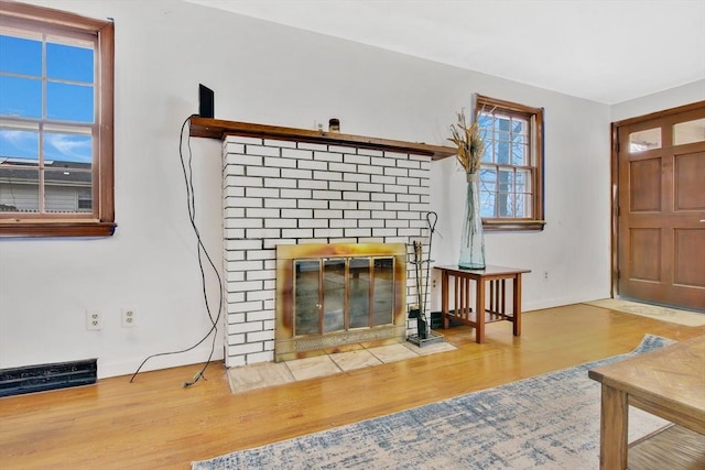 living room with hardwood / wood-style floors and a brick fireplace