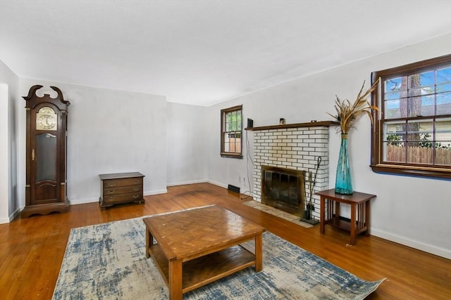 living room featuring hardwood / wood-style flooring and a brick fireplace