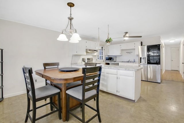 kitchen with white cabinets, ventilation hood, ceiling fan with notable chandelier, decorative light fixtures, and stainless steel appliances