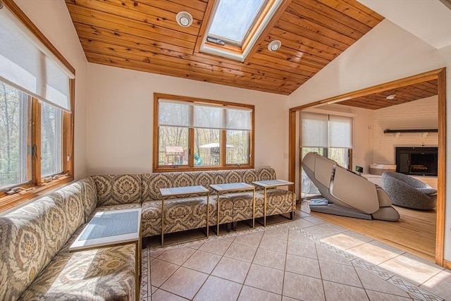 tiled living room with vaulted ceiling with skylight, wood ceiling, plenty of natural light, and a fireplace