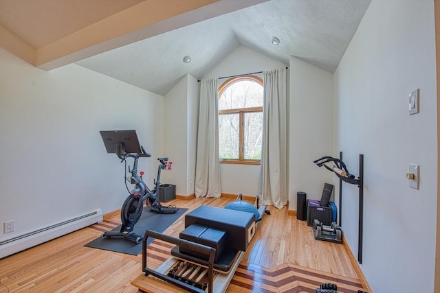 exercise room featuring baseboards, vaulted ceiling, baseboard heating, and wood finished floors
