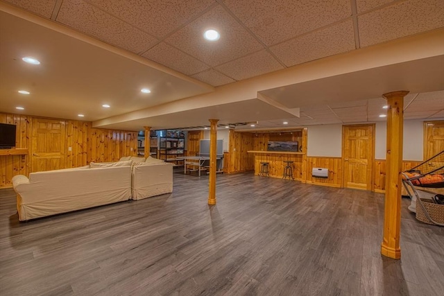 living area featuring wooden walls, recessed lighting, a paneled ceiling, and wood finished floors
