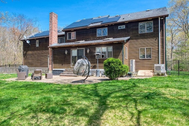 rear view of property featuring a patio area, fence, and a yard