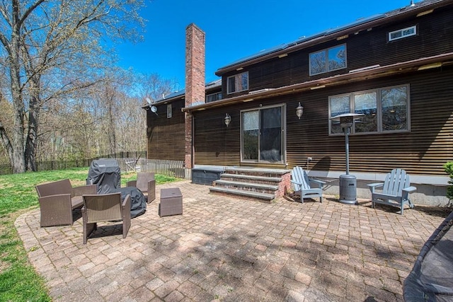 exterior space featuring entry steps, fence, a chimney, and a patio area