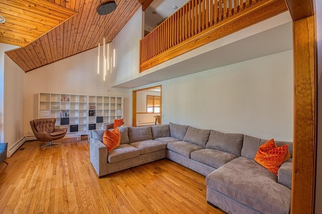 living room with a baseboard radiator, wood ceiling, light wood finished floors, and a towering ceiling