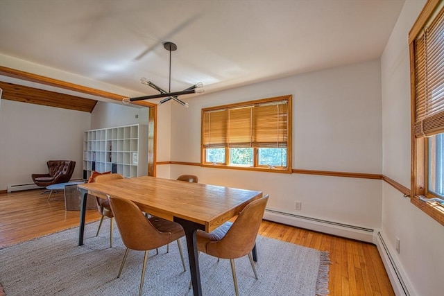 dining area featuring baseboards, a notable chandelier, baseboard heating, and wood finished floors