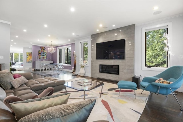 living area with a fireplace, ornamental molding, wood finished floors, and recessed lighting