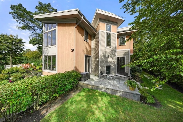 back of property featuring a yard and a patio