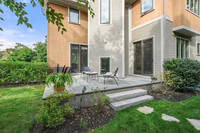 back of house with a patio area and a lawn