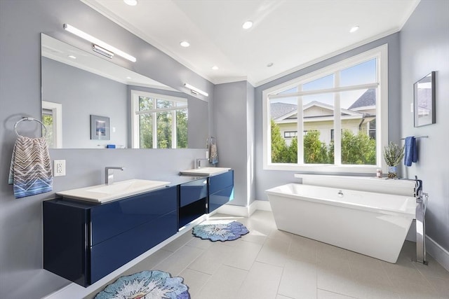 bathroom with ornamental molding, a soaking tub, vanity, and baseboards